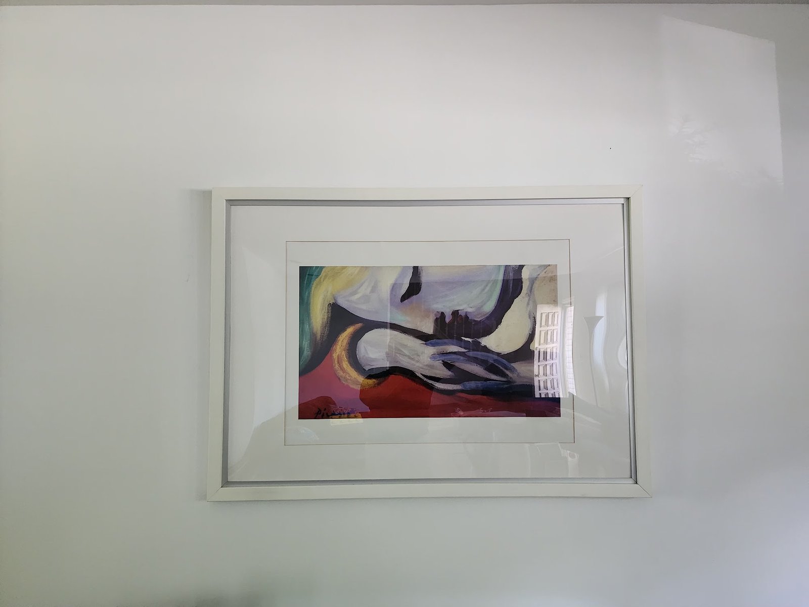 Small framed print hung on a white wall