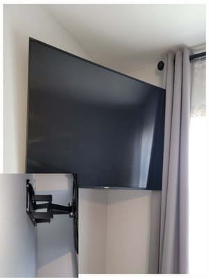 Television mounted on an articulating arm next to a window