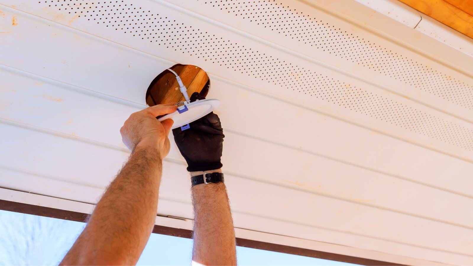 Installer working overhead on a porch ceiling