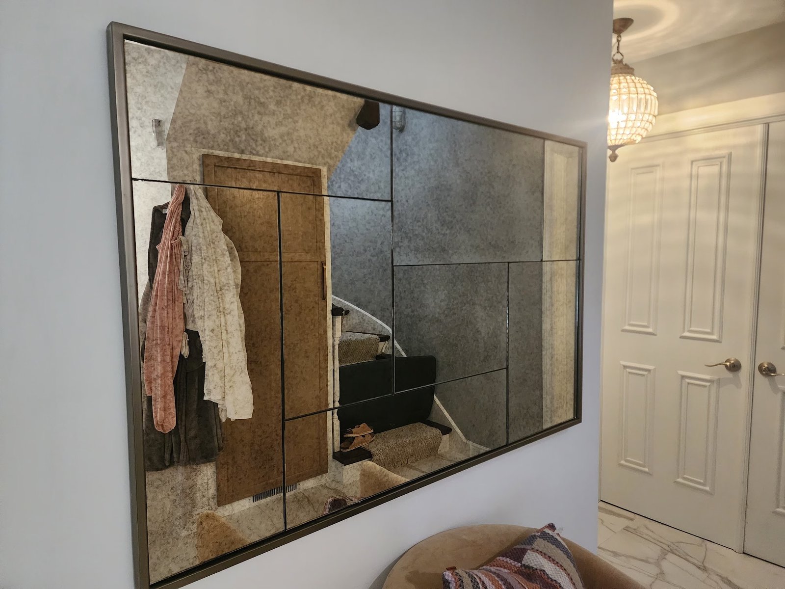 Large framed mirror hung on a bedroom wall