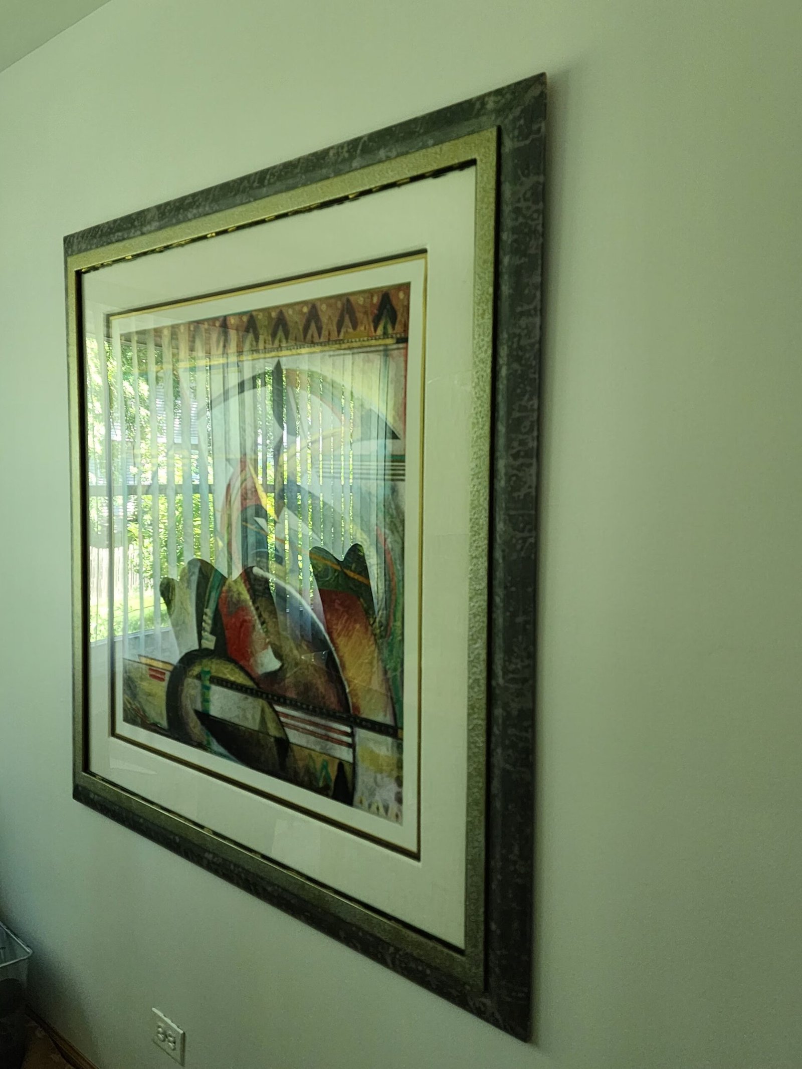 Framed artwork hung beside a window