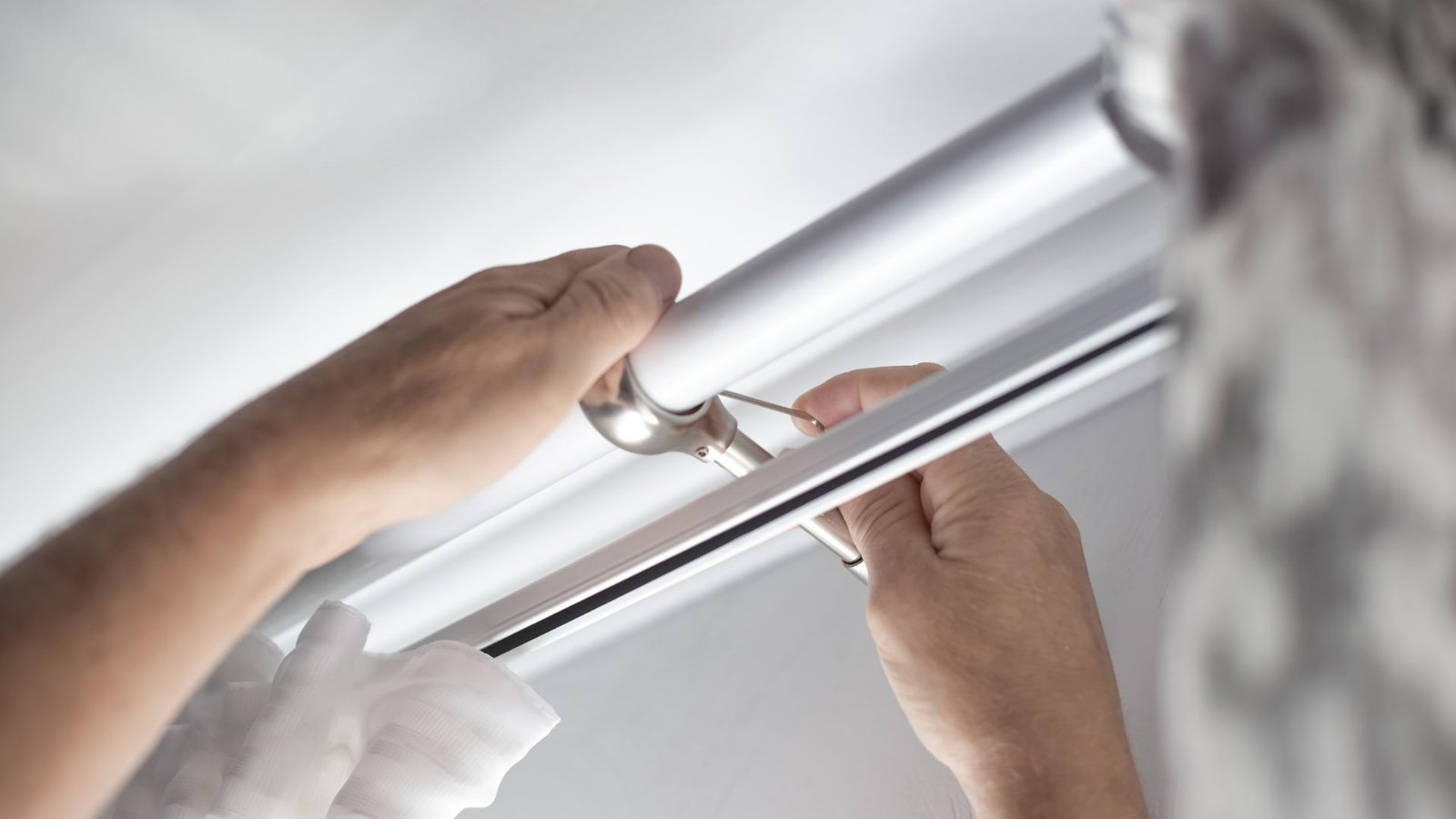 Curtain rod being assembled and installed